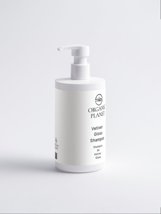 White shampoo bottle with pump on a light gray background. Vetiver Gloss Shampoo gently cleanses and nourishes hair, leaving it smooth, shiny, and healthy. Infused with vetiver oil, glycerin, and squalane, it hydrates and strengthens hair while soothing the scalp. Suitable for all skin types.