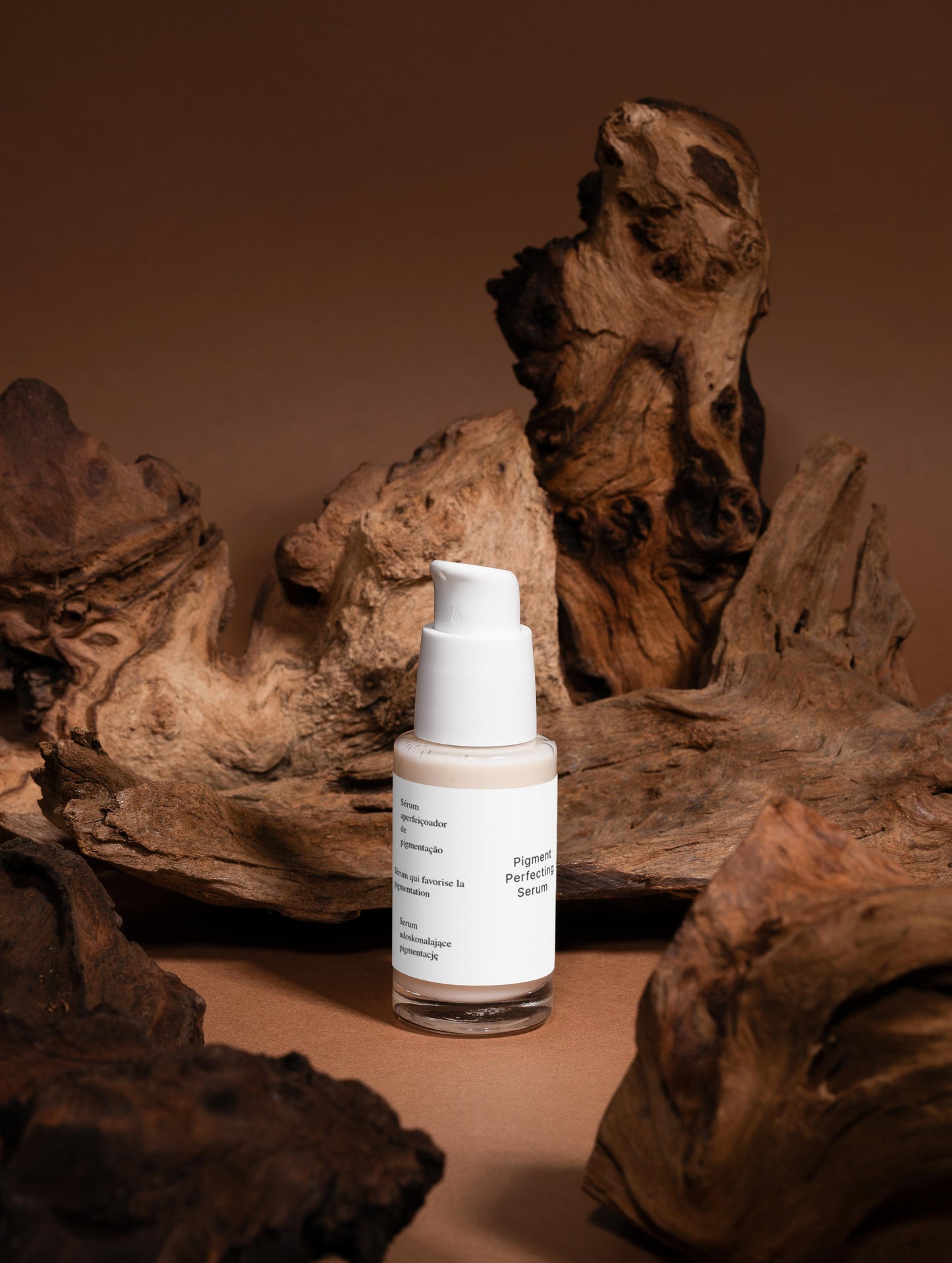 A targeted serum that reduces dark spots and evens skin tone for a brighter, more uniform complexion. The lightweight formula hydrates and soothes while tackling pigmentation concerns. Finished with an elegant blend of vetiver, wood, and almond notes. Skincare bottle with a label on a brown background with natural wood elements.